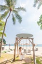 Travel Woman in White Dress and Straw Hat Sitting on Wooden Wings near Blue Sea Royalty Free Stock Photo