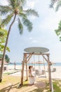 Travel Woman in White Dress and Straw Hat Sitting on Wooden Wings near Blue Sea Royalty Free Stock Photo