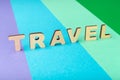 Travel word inscripted with wooden letters on colorful background