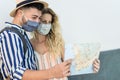 Travel young couple holding city map during a journey while wearing face mask Royalty Free Stock Photo