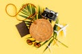 Traveler accessories concept on yellow background. Fashionable handmade natural round rattan bag, retro camera and