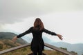 Traveler asia woman look out at viewpoint and feel peace on the woooden fence coner and make wind blow pass arms on Mountain