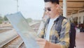 Traveler Asian man direction and looking on location map while spending holiday trip and waiting train at train station, Young Royalty Free Stock Photo