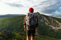 A traveler on the background of mountains. A tourist with a backpack is standing on the top of the mountain. A man with a backpack Royalty Free Stock Photo