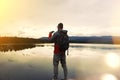 Traveler with a backpack and binoculars looking at the lake