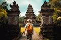 Traveler with backpack and hat walking at Pura Besakih temple in Bali, Indonesia, Tourist woman with backpack at vacation walking