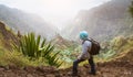 Traveler with backpack looking over the rural landscape with mountain peaks and ravine in dust air on the path from Xo Royalty Free Stock Photo