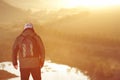 A traveler with a backpack on the mountain meets the sunrise