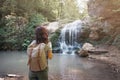 Traveler backpacker girl enjoying view of waterfall.