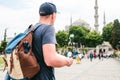 A traveler in a baseball cap with a backpack is looking at the map next to the blue mosque - the famous sight of Royalty Free Stock Photo