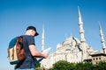 A traveler in a baseball cap with a backpack is looking at the map next to the blue mosque - the famous sight of Royalty Free Stock Photo