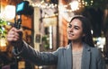 Traveler blogger shoot video for vlog social media with digital camera. Smiling woman vlogger taking photo selfie on background