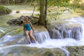 Traveler in blue swimsuit beautiful relax at Erawan Waterfall