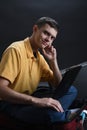 Expressive man using laptop computer and his luggage