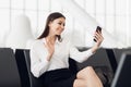 Traveler businesswoman with smartphone, waving hand for greeting in front camera during video call, waiting in lobby Royalty Free Stock Photo