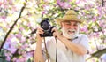Traveler camera man under sakura bloom garden. travel concept. male photographer enjoy cherry blossom. travel and