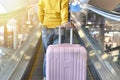 Traveler carry big suitcase on escalator walkway at the airport terminal.