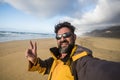 Traveler cheerful happy people man taking a selfie picture in a wild scenic place lonely beach with mountains in backgorund - Royalty Free Stock Photo