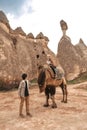 Traveler couple with camel at Goreme fairy chimneys , Cappadocia. Nevsehir Province. Turkey Royalty Free Stock Photo