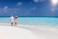 Traveler couple walks down a tropical beach Royalty Free Stock Photo