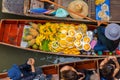 Traveler enjoying and take a photo with smartphone on long trail boat at Damnoen Saduak floating market