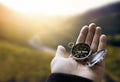 Traveler explorer man holding compass in a hand in mountains at sunrise, point of view Royalty Free Stock Photo