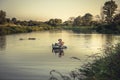 Traveler explorer traveling on river boat during travel adventure expedition at sunset Royalty Free Stock Photo