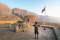 Traveler exploring Dhayah Fort in north Ras Al Khaimah United Arab Emirates at sunset