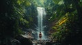 Traveler exploring a hidden waterfall in a dense tropical rainforest Royalty Free Stock Photo