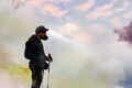 Traveler in a face protective mask in the crater of a volcano. Sulfur clouds and pink sunrise. A dangerous journey into the crater