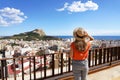 Traveler girl enjoying view of Alicante cityscape and Mount Benacantil with Santa Barbara Castle and sea on background, Spain