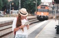 Traveler girl waiting and boarding a train on railway platform. Royalty Free Stock Photo