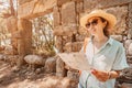 Girl reading map at the ancient ruins of antique Greek city of Phaselis in Turkey. Historical sightseeing and archeology Royalty Free Stock Photo