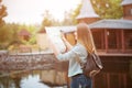 Traveler girl searching right direction on map, orange sunset light, traveling along Europe Royalty Free Stock Photo