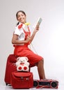 Traveler girl sitting on her luggage with a book