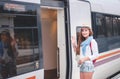 Traveler girl waiting and boarding a train on railway platform. Royalty Free Stock Photo