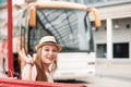 Traveler girl waves her hand at the bus station, waiting for her Royalty Free Stock Photo