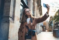 Traveler in glasses self cellphone internet technology in europe trip. Tourist girl taking photo selfie on smartphone online mobil