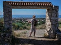 The traveler guy stands with a map of the area stands in a stone gate destroyed, rear view