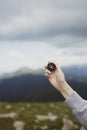 Traveler hand holds compass against beautiful Carpathian mountains view. Horizontal banner with place for text. Royalty Free Stock Photo