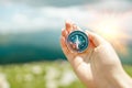 Traveler hand holds a compass on the beautiful Carpathian mountains view. Horizontal banner with place for text Royalty Free Stock Photo