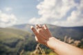 Traveler hand reaching out to mountains with engagement ring. gi