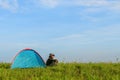 Traveler having camping with a tent on grass field