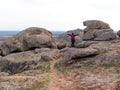 Traveler hiker woman with raised hands backpack raincoat on mountain summit. Girl backpacker enjoying scenic landscape Royalty Free Stock Photo