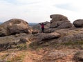 Traveler hiker woman with raised hands backpack raincoat on mountain summit. Girl backpacker enjoying scenic landscape Royalty Free Stock Photo