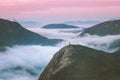 Traveler hiking above mountain clouds enjoying Norway sunset landscape Royalty Free Stock Photo