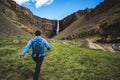Traveler hiking at Hengifoss Waterfall, Iceland