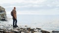 Traveler hipster man standing on coastline near the sea Royalty Free Stock Photo