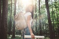 Traveler hipster woman with backpack and hat hold in hands location map and searching directional among trees in forest