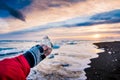 Traveler holding ice chunk on Diamond beach in Iceland